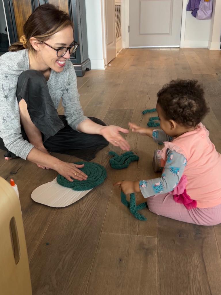 Meg and her daughter working together on a green coiled-yarn canopy for handmade sensory tree wall art.