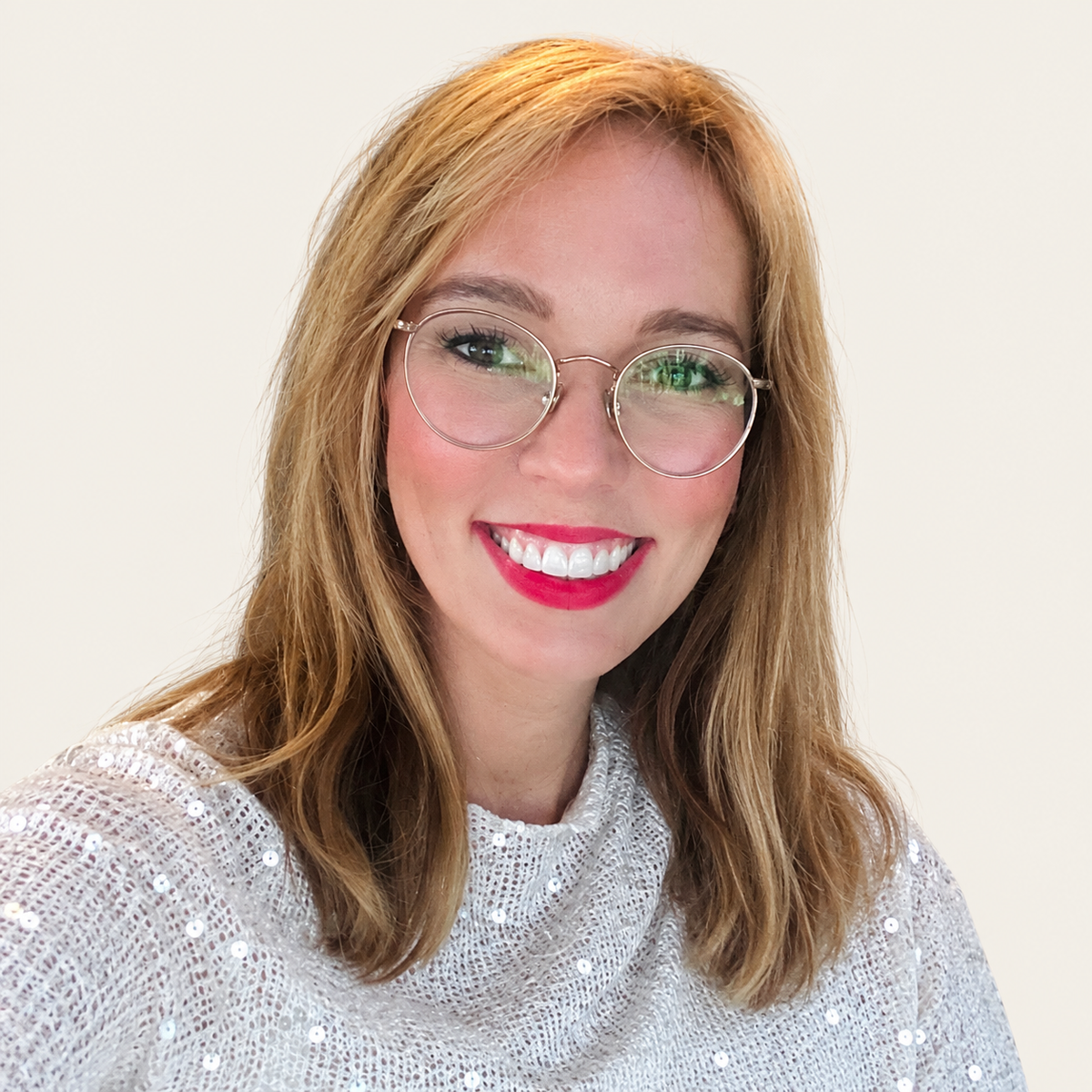 Meg, founder and chief artist of That Playful Life, smiling in a portrait against a warm beige background.